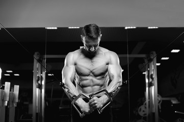 Fototapeta na wymiar Male fitness model with naked torso posing in gym