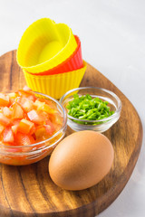 Fresh chopped vegetables and eggs - ingredients for egg muffins. 