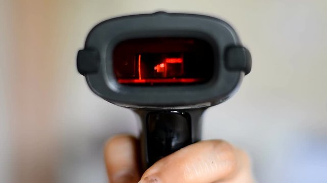 woman hold scanner and scans barcode with laser