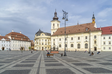 Fototapeta na wymiar Benches on the famous Piata Mare, Large Square, in a moment of tranquility, Sibiu, Romania, with the Holy Trinity church in the background