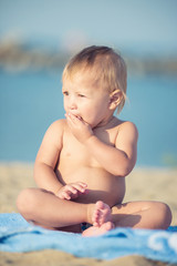 Baby playing with toys on the sandy beach near the sea. Cute little kid in  sand on tropical beach. Ocean coast.