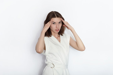 Young beautiful brunette beginner model woman in white blouse practicing posing showing emotions on white wall studio background