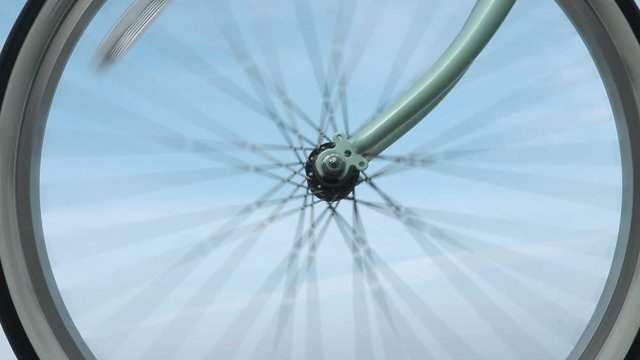 Bicycle wheel rotates against the blue sky in slow motion close-up