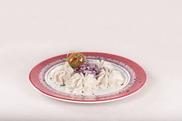 Fish roe salad, whit toasted bread, onion, green leafs, lemon, radish and olives, placed on a white plate, brown background