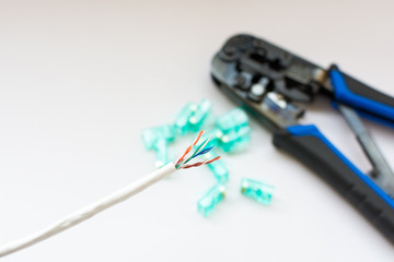 LAN cable with RJ-45 Jack and crimp tool on white background
