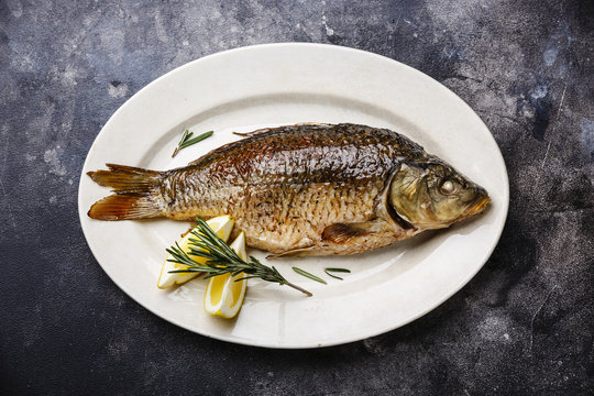 Baked carp roasted with lemon on plate