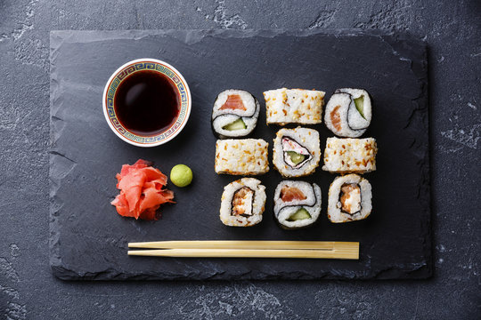 Sushi rolls Yin Yang shape on stone slate on black stone background