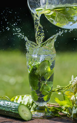 Glass with mineral water with cucumber and mint - home made lemonade