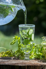 Glass with mineral water with cucumber and mint - home made lemonade