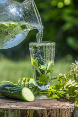 Glass with mineral water with cucumber and mint - home made lemonade