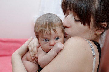 Portrait of a baby in her mother's arms at home