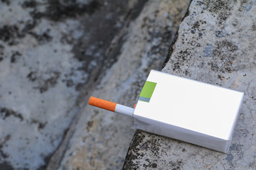 closeup cigarette in the package on cement background. concept Non-smoking day universal