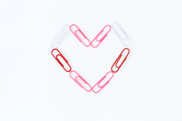 heart shape by paper clips on white background