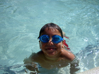 a boy is swimming with goggles in swimming pool gold cost Australia