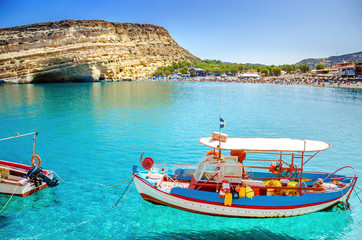 Matala beach, old fishing boat and caves on the rocks that were used as a roman cemetery and at the decade of 70's were living hippies from all over the world, Crete, Greece. Rock festival.f