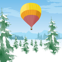 Obraz premium Air balloon flying over coniferous forest in a snowy valley