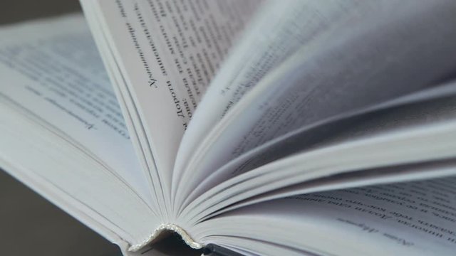 Book pages. The book, reading. A woman's hand holds the pages of the book. A woman's hand turns over the pages of the book. Concept: reading, books, bookmark.