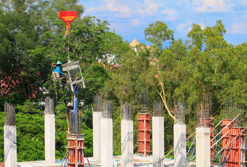 Naklejka premium crane lifting concrete mixer container and worker in construction building commercial in site workplace