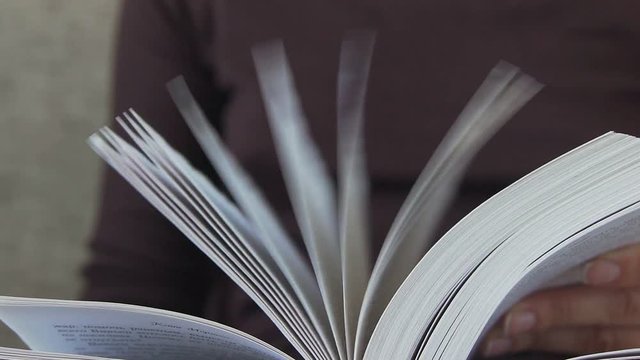 Book pages. The book, reading. A woman's hand holds the pages of the book. A woman's hand turns over the pages of the book. Concept: reading, books, bookmark.