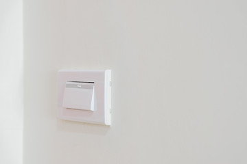Switch on the wall to turn on the electricity to illuminate the room.