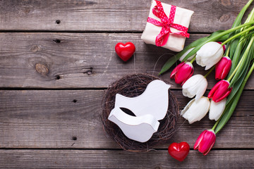 Decorative birds in nest, bright  spring  tulips flowers, box with present and red little hearts