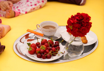 A breakfast tray with coffee on a bed.