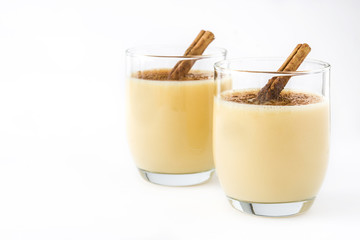 Homemade eggnog with cinnamon isolated on white background. Typical Christmas dessert.

