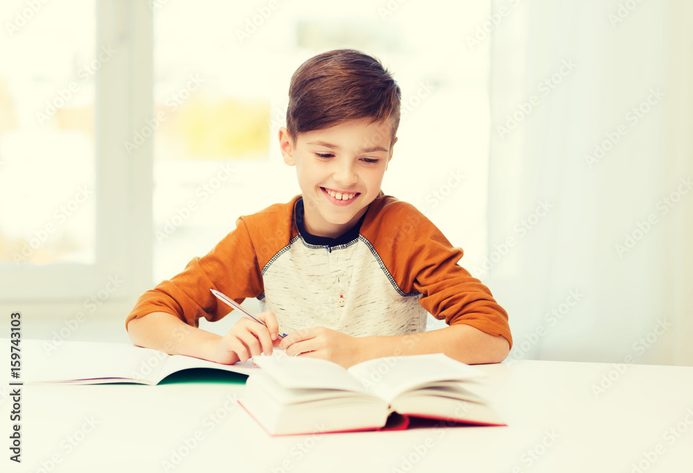 Poster smiling student boy writing to notebook at home