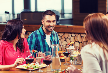 happy friends having dinner at restaurant