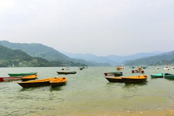 Fototapeta premium Boats hangared in Phewa Lake, Pokhara second largest freshwater lake in Nepal, famous for the reflection of Machhapuchhre & other mountain peaks on its surface.