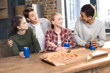 happy friends spending time together with pizza and soda drinks, eating pizza at home concept