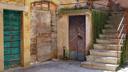 Fototapeta na wymiar Drei Holztüren und eine Treppe in Torri del Benaco