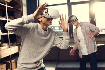 teenage boys wearing virtual reality headsets at home, teenagers playing video games concept