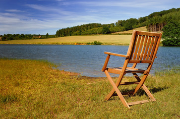 chaise en bois sur les berges d'un lac