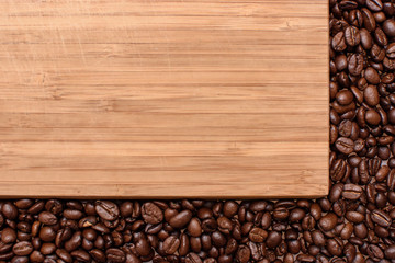 A wooden background around the edges sprinkled with roasted grain coffee, space for text