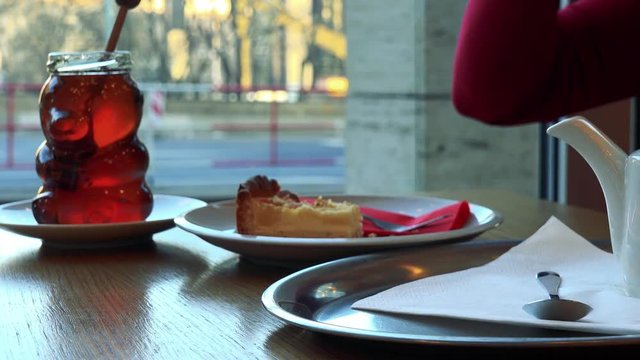 A woman sits at a table with meal in a cafe and drinks tea - closeup on the table
