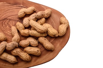 Peanuts in a shell on a wooden board isolated on a white background