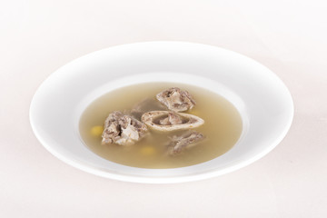 Bone marrow soup, served in a white bowl, light background, isolated