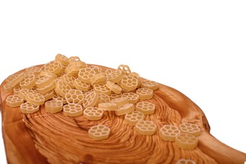 Macaroni on a wooden board of olive tree isolated on a white background