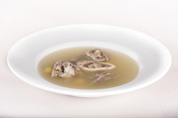 Bone marrow soup, served in a white bowl, light background, isolated
