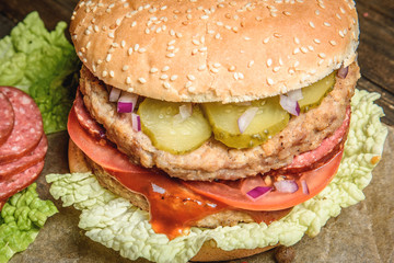 Burger with salami and vegetables