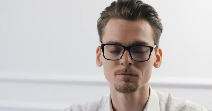 Portrait of smart casual creative young man in trendy glasses working at modern office.
