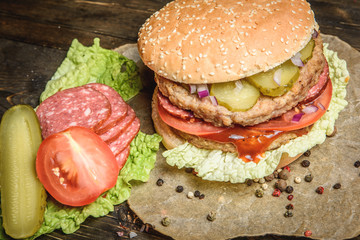 Burger with salami and vegetables