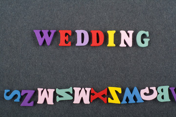 WEDDING word on black board background composed from colorful abc alphabet block wooden letters, copy space for ad text. Learning english concept.