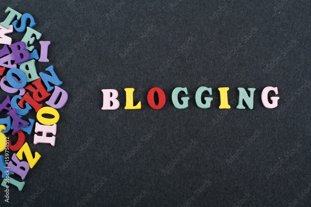 Fototapete blogging word on black board background composed from colorful abc alphabet block wooden letters, co
