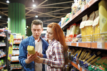 young couple chooses foods at the supermarket