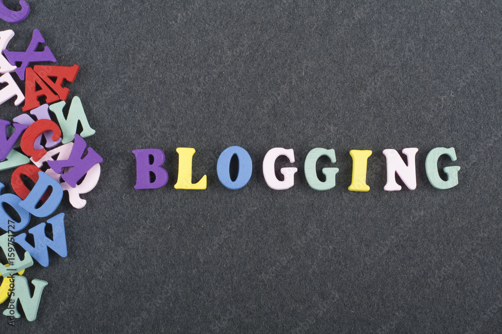 Fototapete blogging word on black board background composed from colorful abc alphabet block wooden letters, co