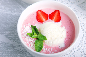 Cold creamy strawberry soup with a scoop of ice cream and mint