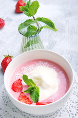Cold creamy strawberry soup with a scoop of ice cream and mint