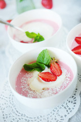 Cold creamy strawberry soup with a scoop of ice cream and mint